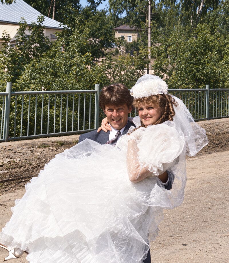Restored color photo of the groom carrying the bride