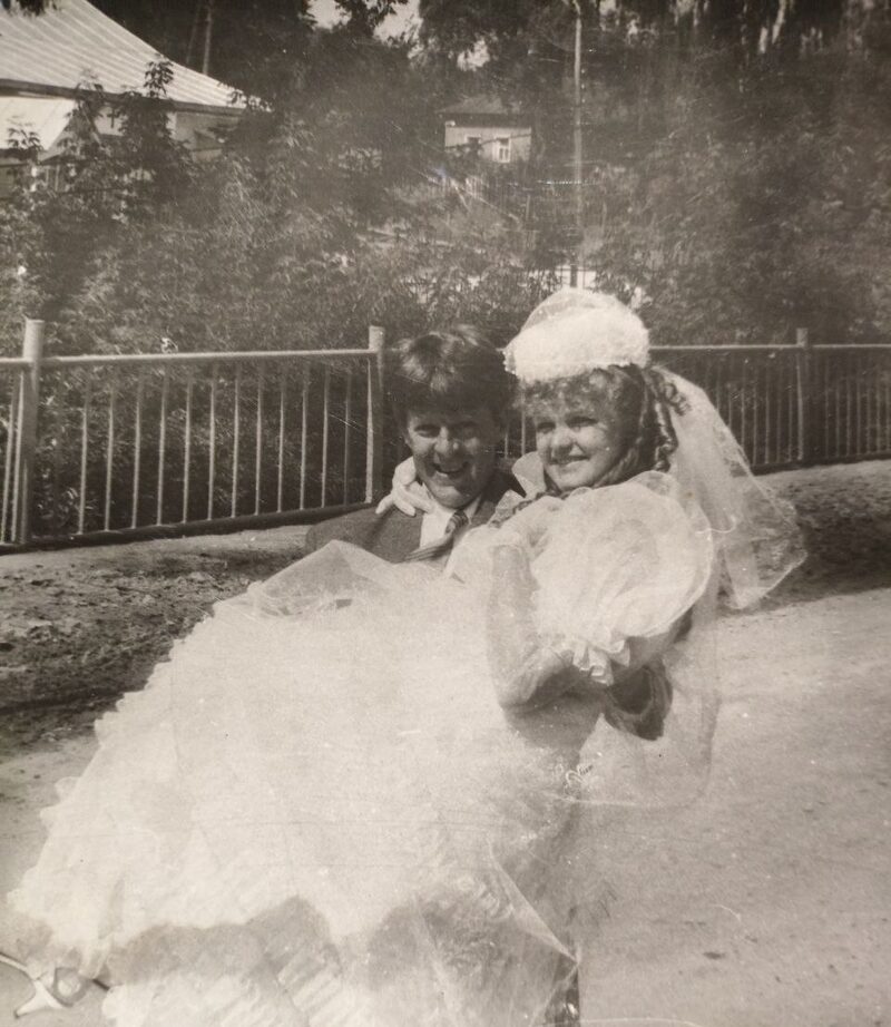 Black-and-white photo of the groom carrying the bride